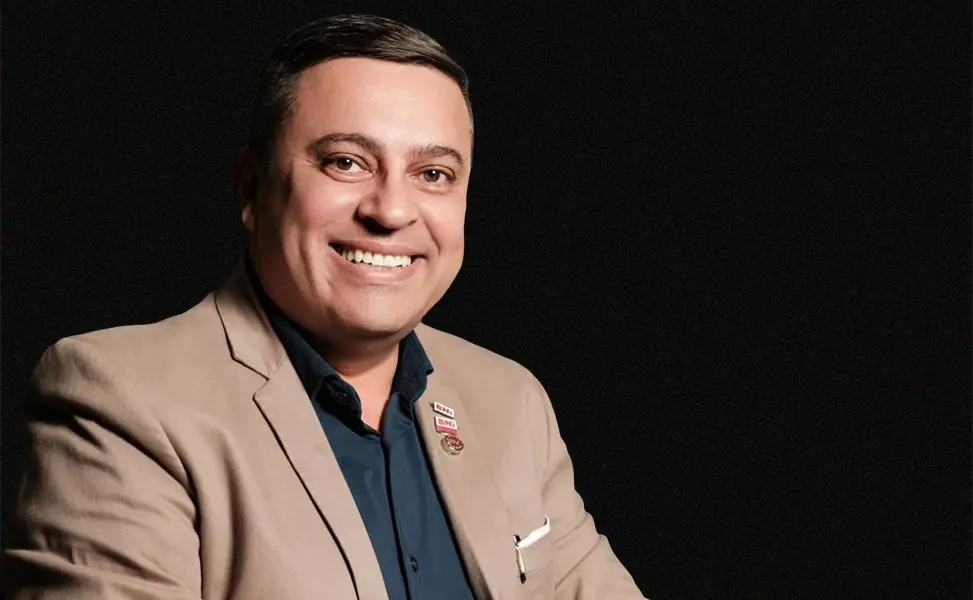 Anderson de Oliveira, fundador da MSR Device Golden Store, em pose descontraída com blazer bege e camisa escura