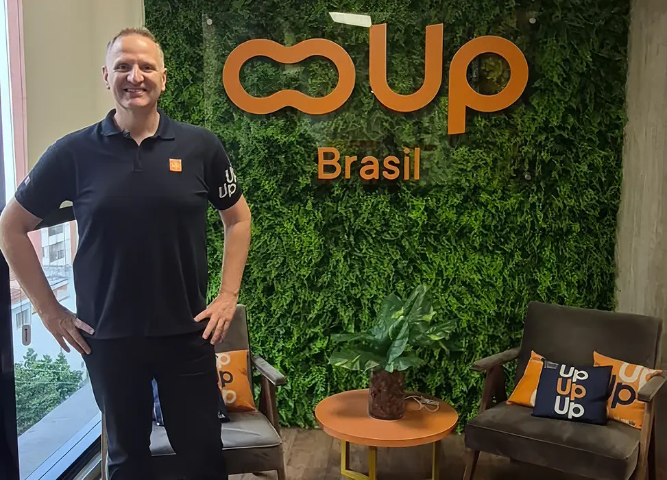 Thomas Pillet diante do painel verde com a identidade visual da Up Brasil, na sede da empresa